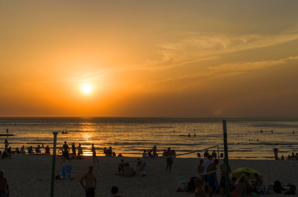 Schöner Sonnenuntergang am Ramirez-Strand mit Sommerbadenden